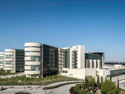 Un gran edificio con muchas ventanas y un cielo azul al fondo.