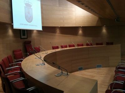 Una sala de conferencias con una mesa curva y sillas.