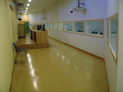 Un largo pasillo con una silla y un proyector en la pared.