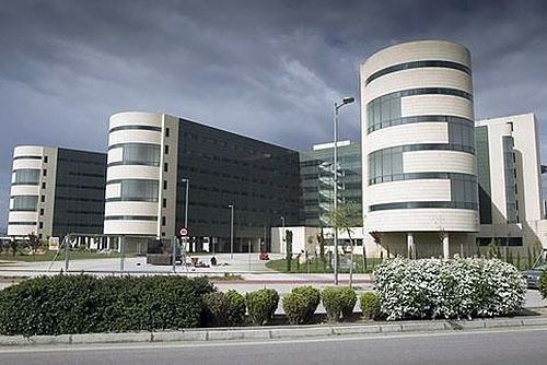 Un gran edificio con muchas ventanas está al lado de una carretera.