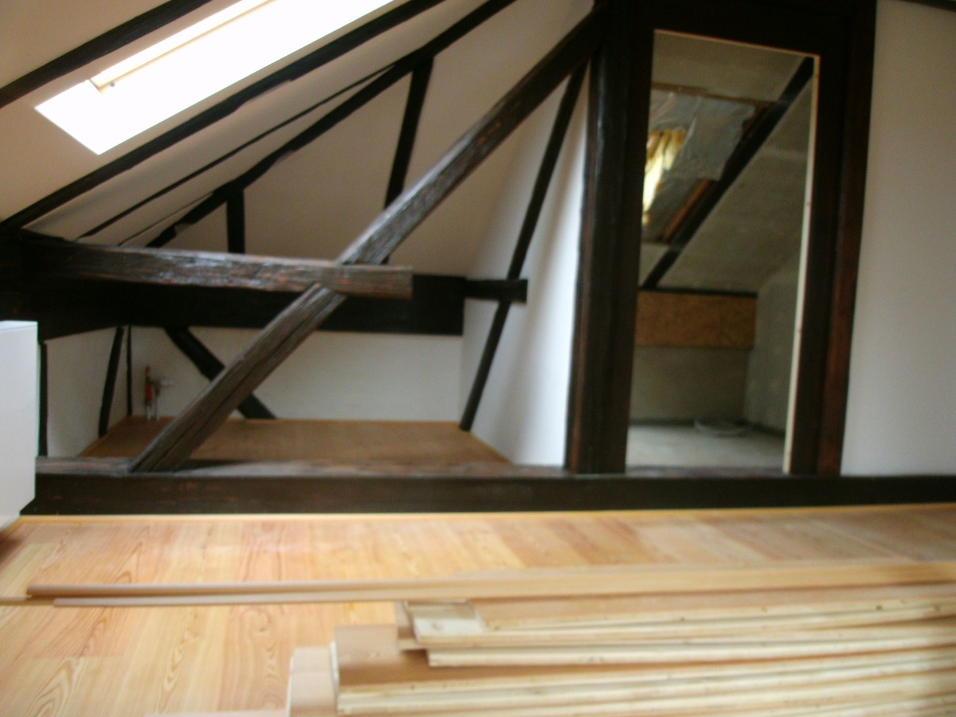 Holzlattenwand mit Sonnenlicht, Regalen und einer weißen Wand.