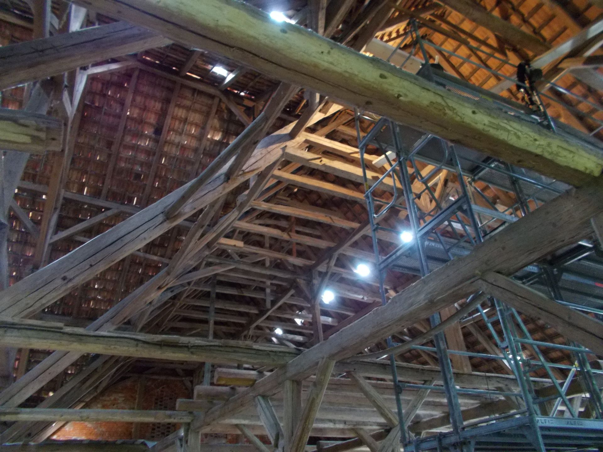 Person, die einen Holztisch im Innenbereich mit einem Pinsel grau streicht.