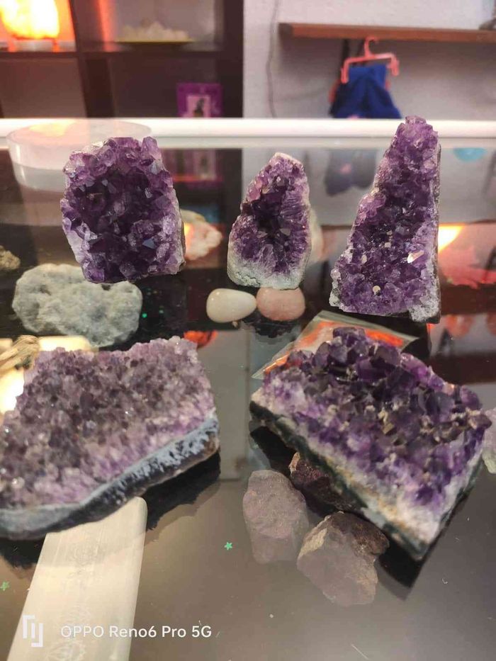 En una tienda, cuelgan collares de las ramas de un árbol decorativo expuesto en el exterior.