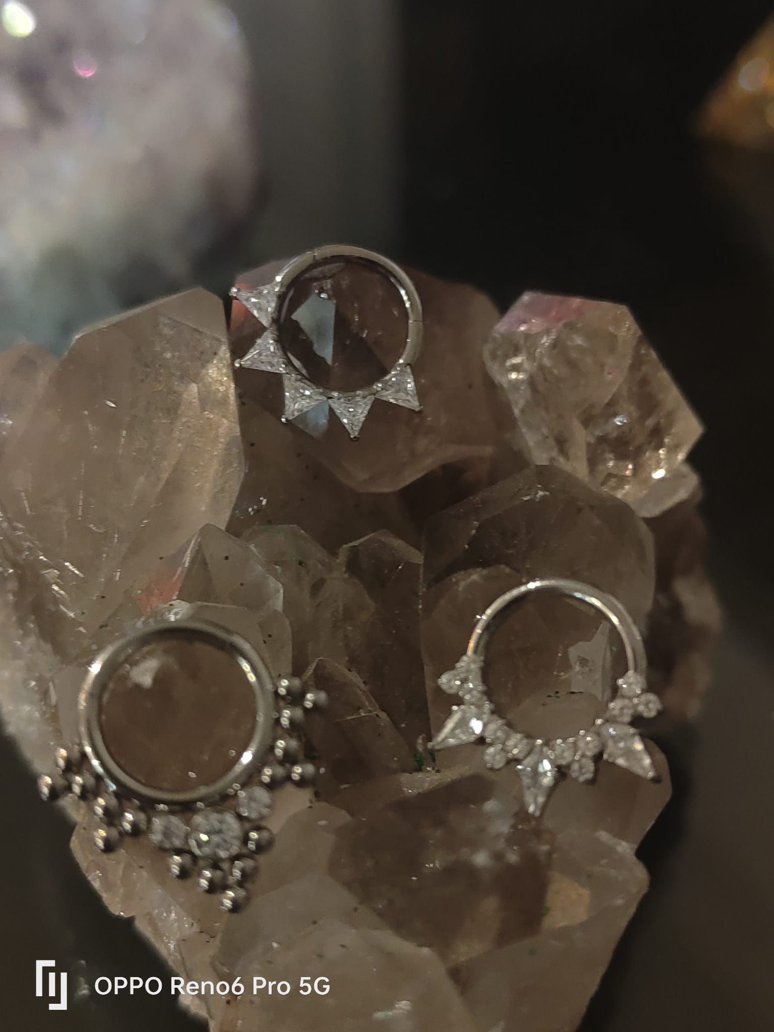 Tres elaborados pendientes de aro de plata con detalles decorativos incrustados de cristales.