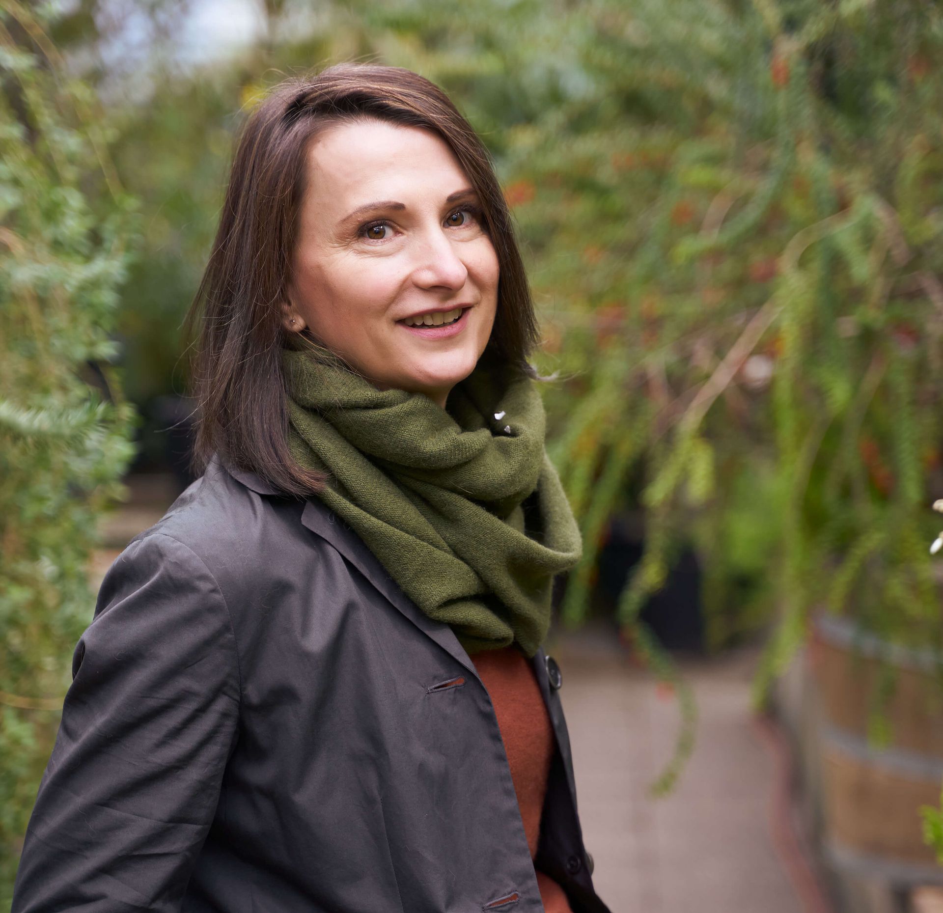 Frau in dunkler Jacke und grünem Schal