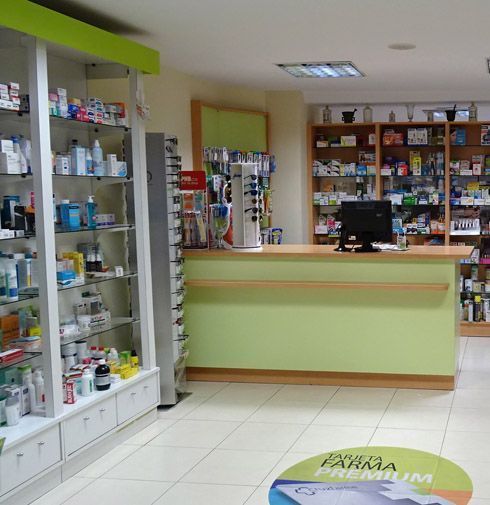 El interior de una farmacia con un mostrador verde.