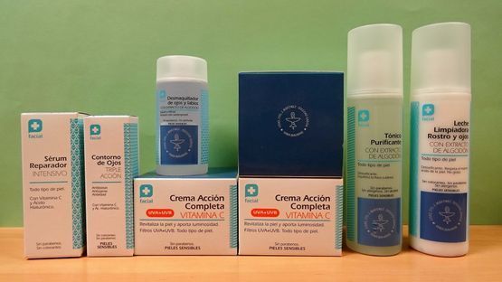 Una fila de botellas y cajas de cosméticos sobre una mesa.
