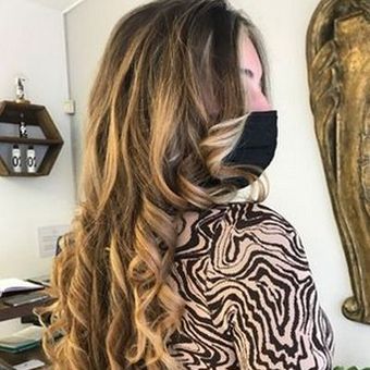 Una mujer que lleva una máscara y una camiseta con estampado de cebra está parada en una habitación.