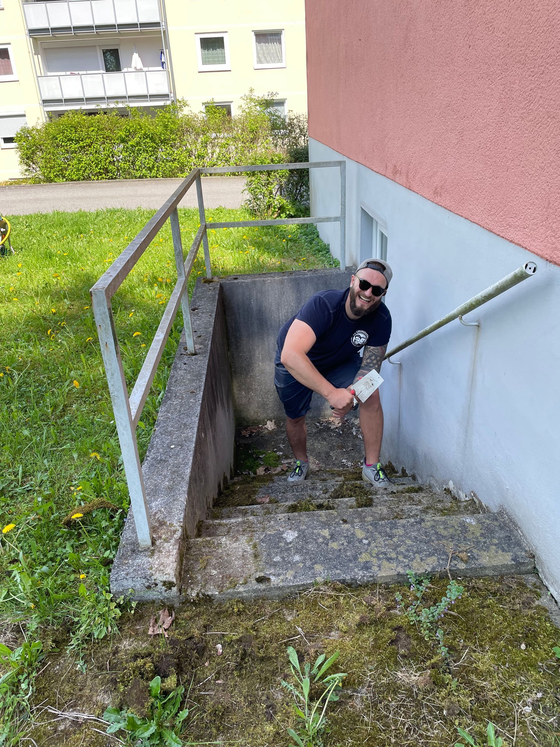 Ein Klempner justiert einen wandmontierten Heizkessel mit roten und blauen Rohren in einem gefliesten Hauswirtschaftsraum.