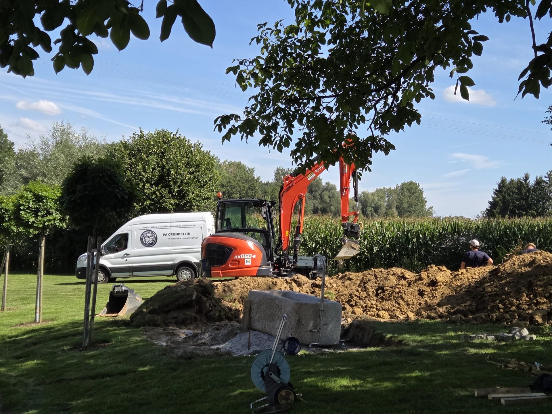 Ein Arbeiter in einer gelben Sicherheitsweste schreibt auf einem Klemmbrett an einer Baustelle.