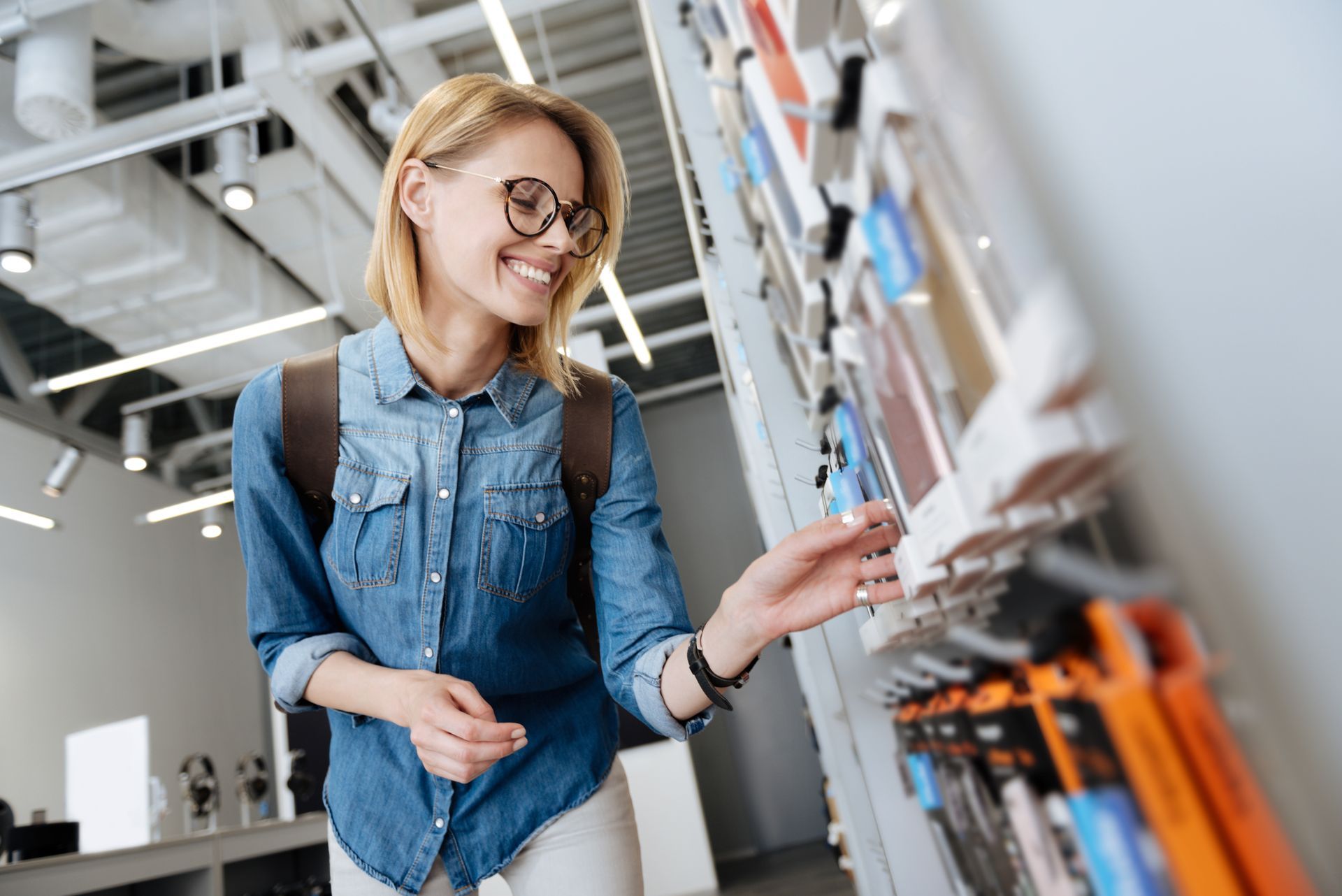 Une femme dans un magasin en train de choisir un téléphone portable