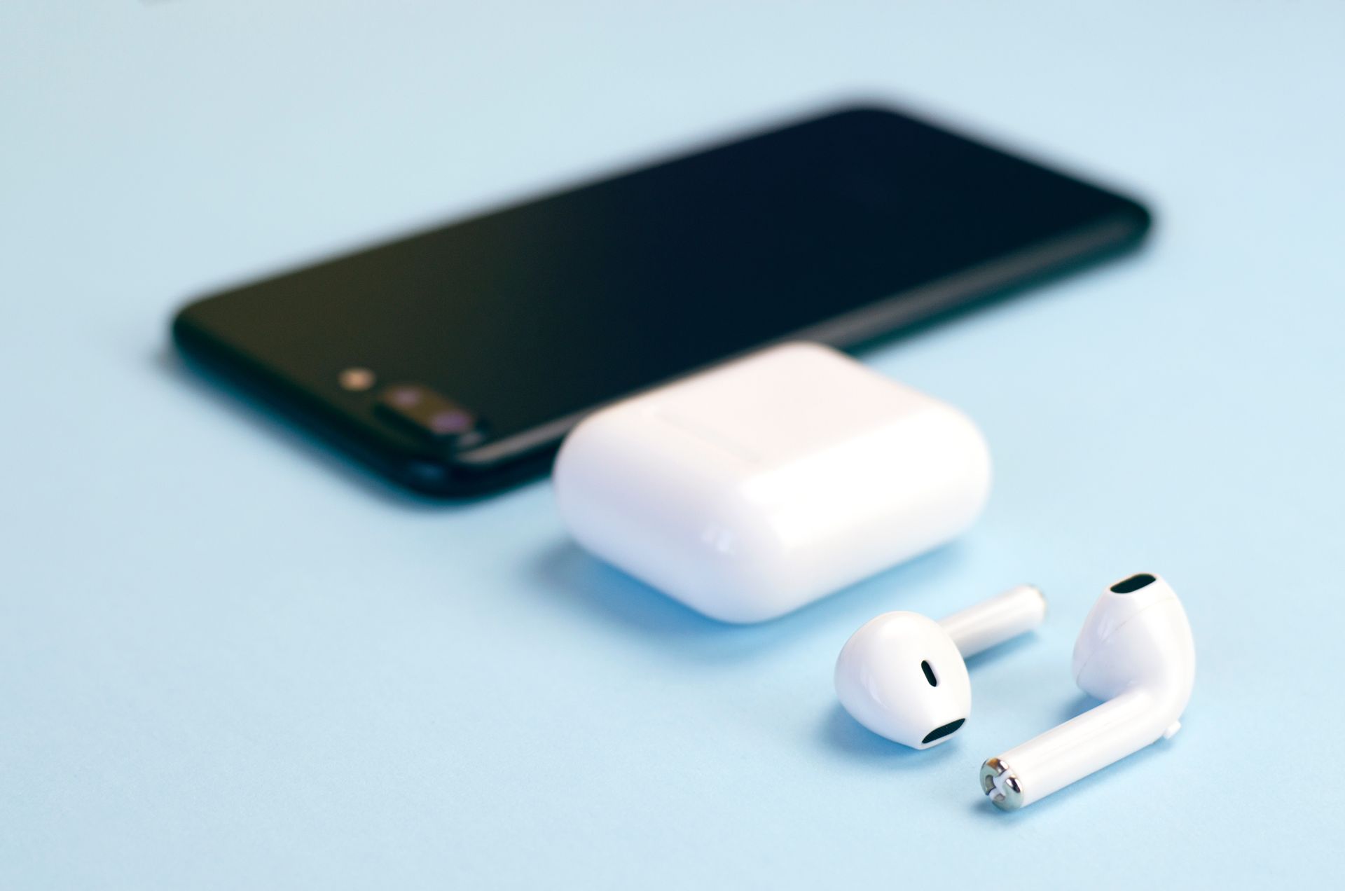 Un portable et des écouteurs sans fils posés sur une table