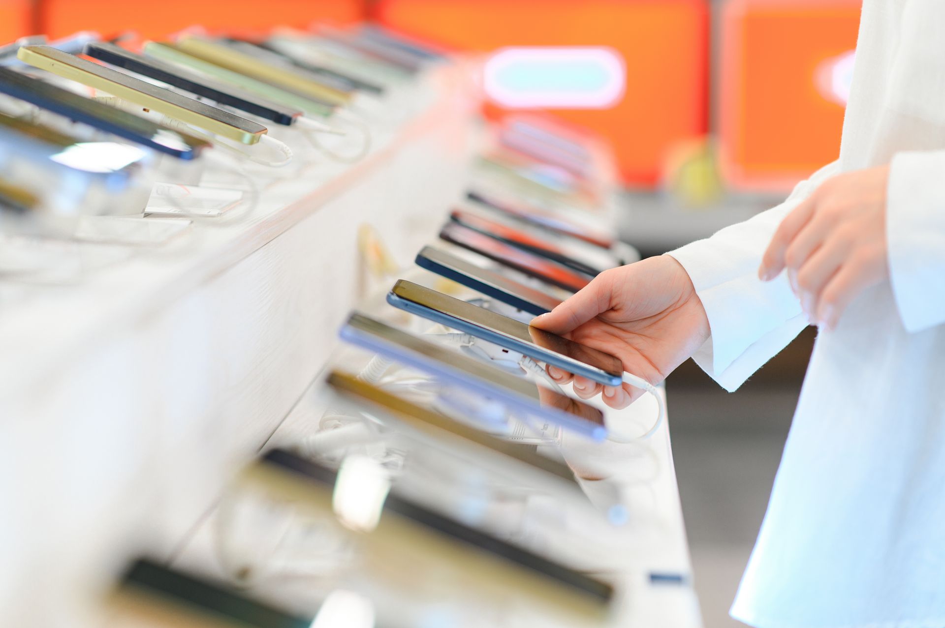 Une femme qui prend un téléphone dans un magasin pour l'essayer