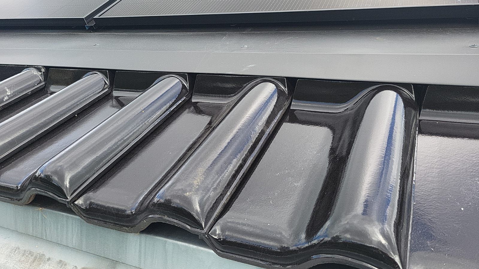 Eine Nahaufnahme einer Reihe schwarzer Dachziegel.