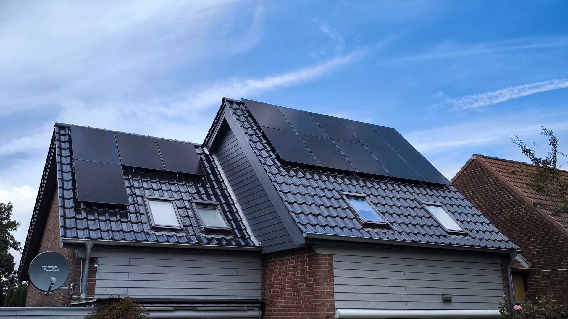 Ein Haus mit vielen Solarmodulen auf dem Dach.