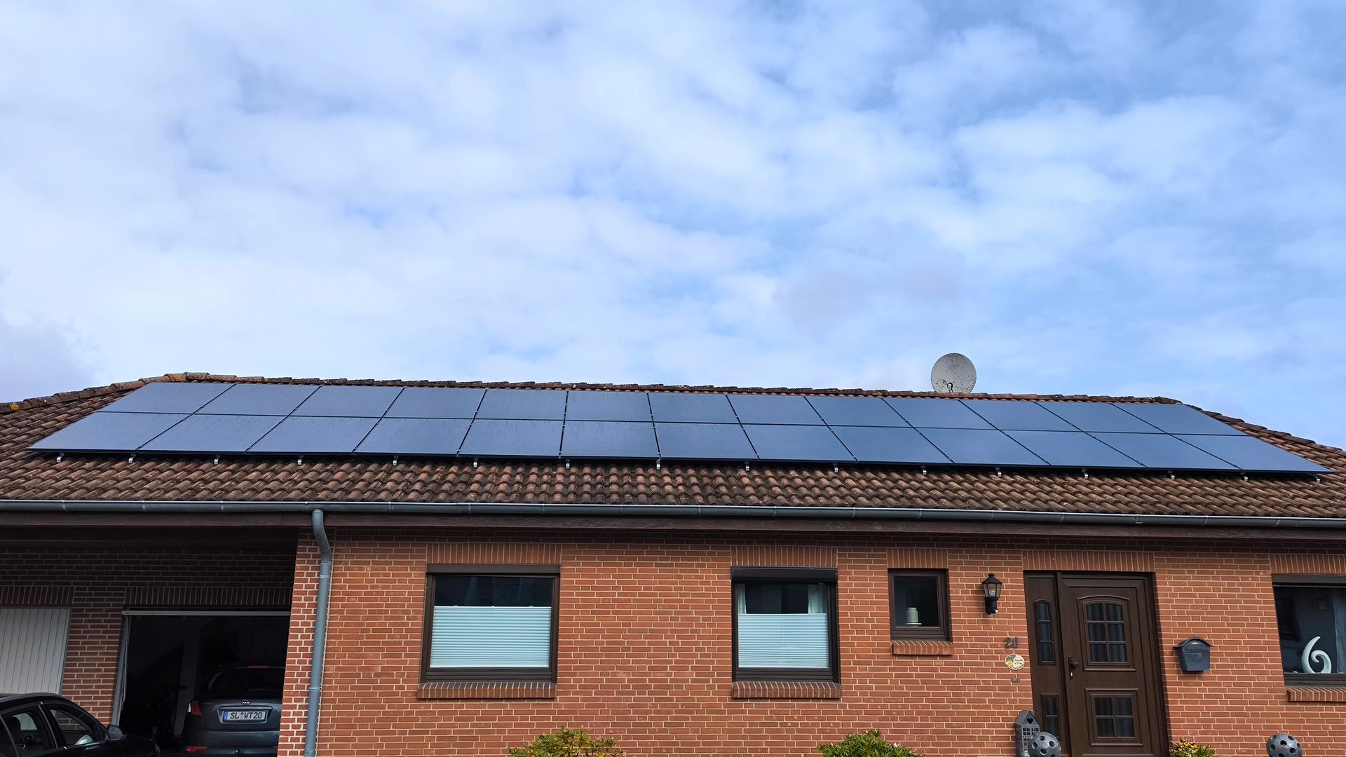 Ein Backsteinhaus mit Sonnenkollektoren auf dem Dach.
