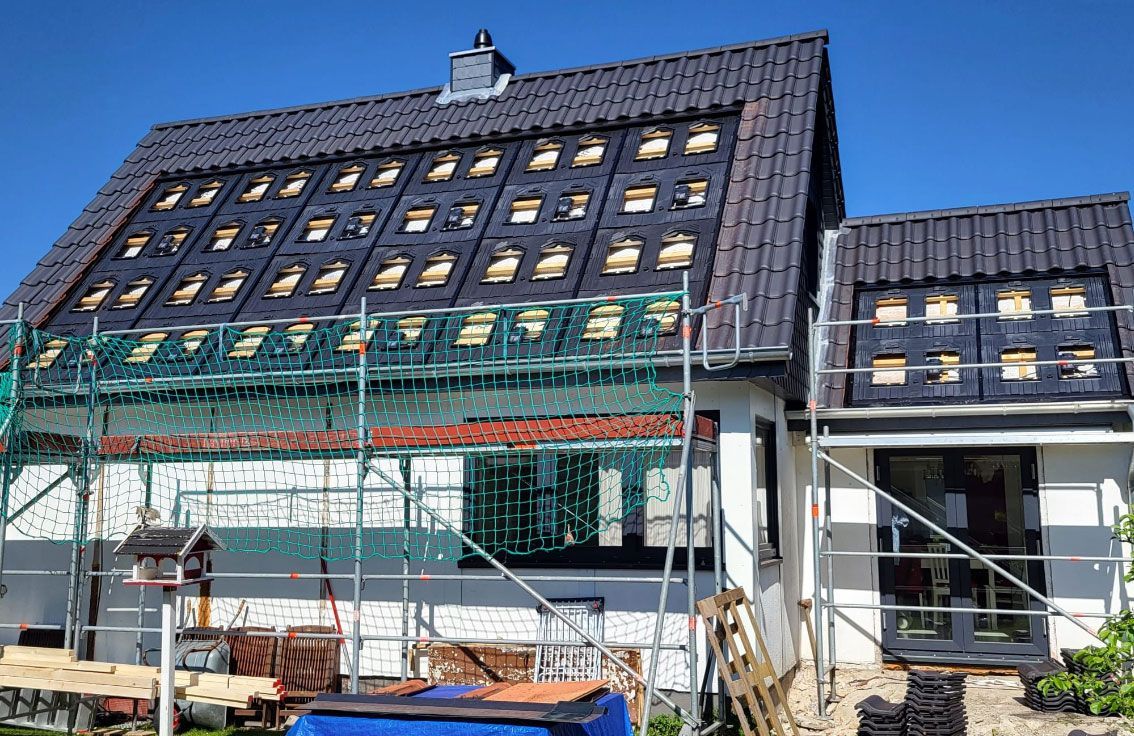 Es wird ein Haus mit einer Solaranlage auf dem Dach gebaut.