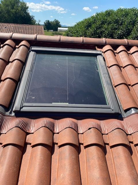 Fenêtre de toit sur un toit de tuiles.