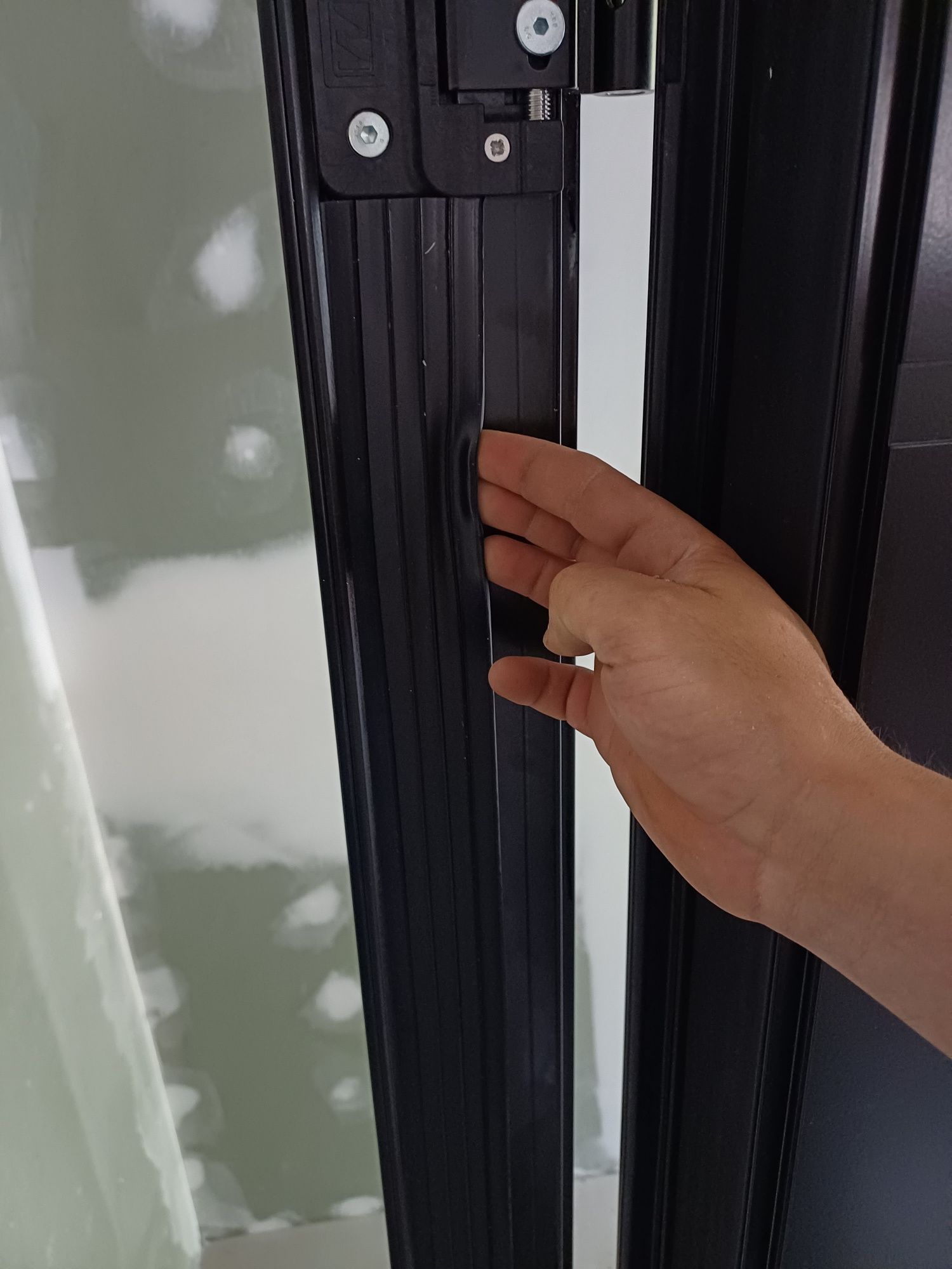 Eine Person mit einem Ring am Finger öffnet eine Tür.