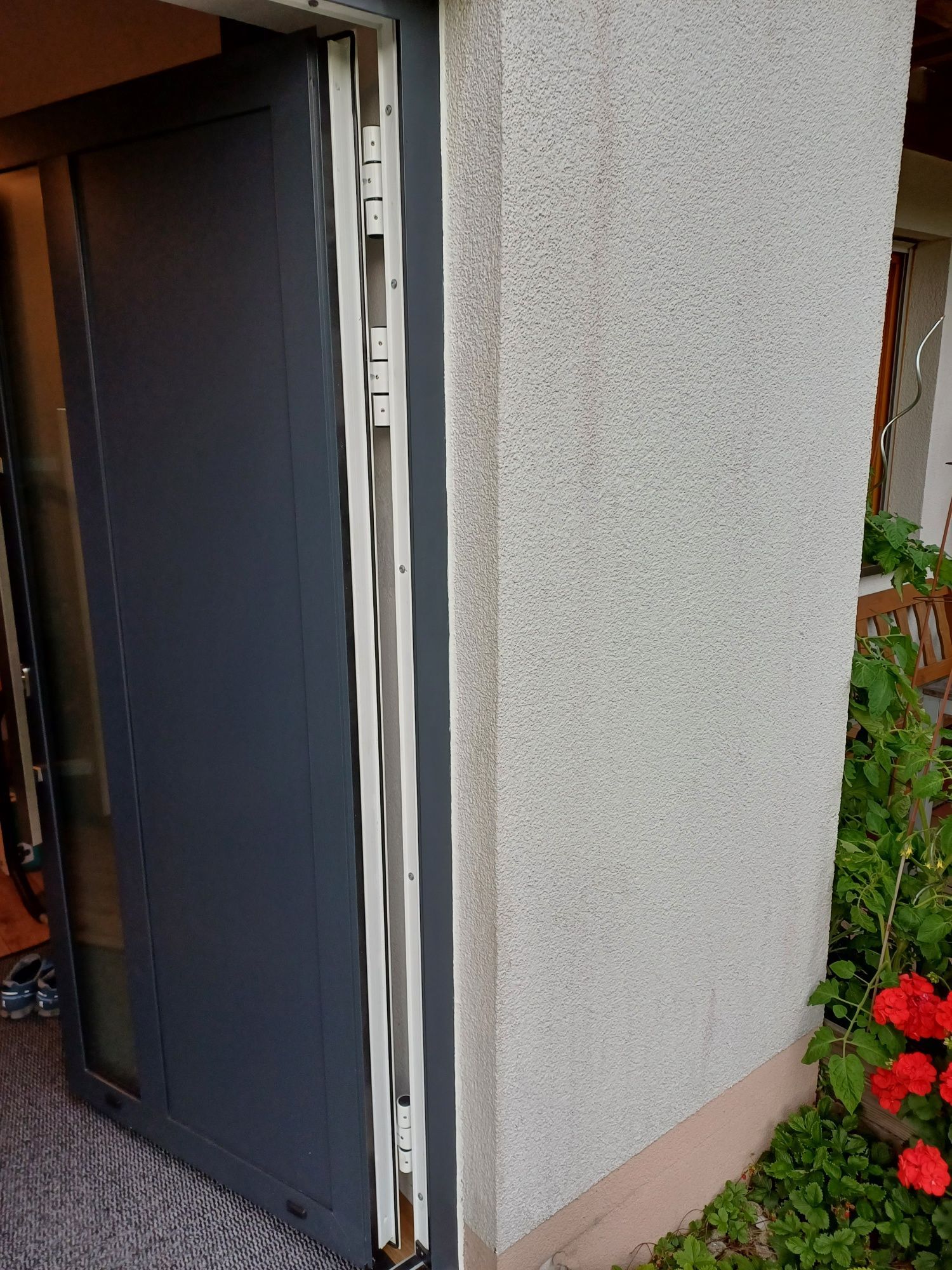 Eine Nahaufnahme einer Tür an einem Gebäude mit Blumen im Hintergrund.