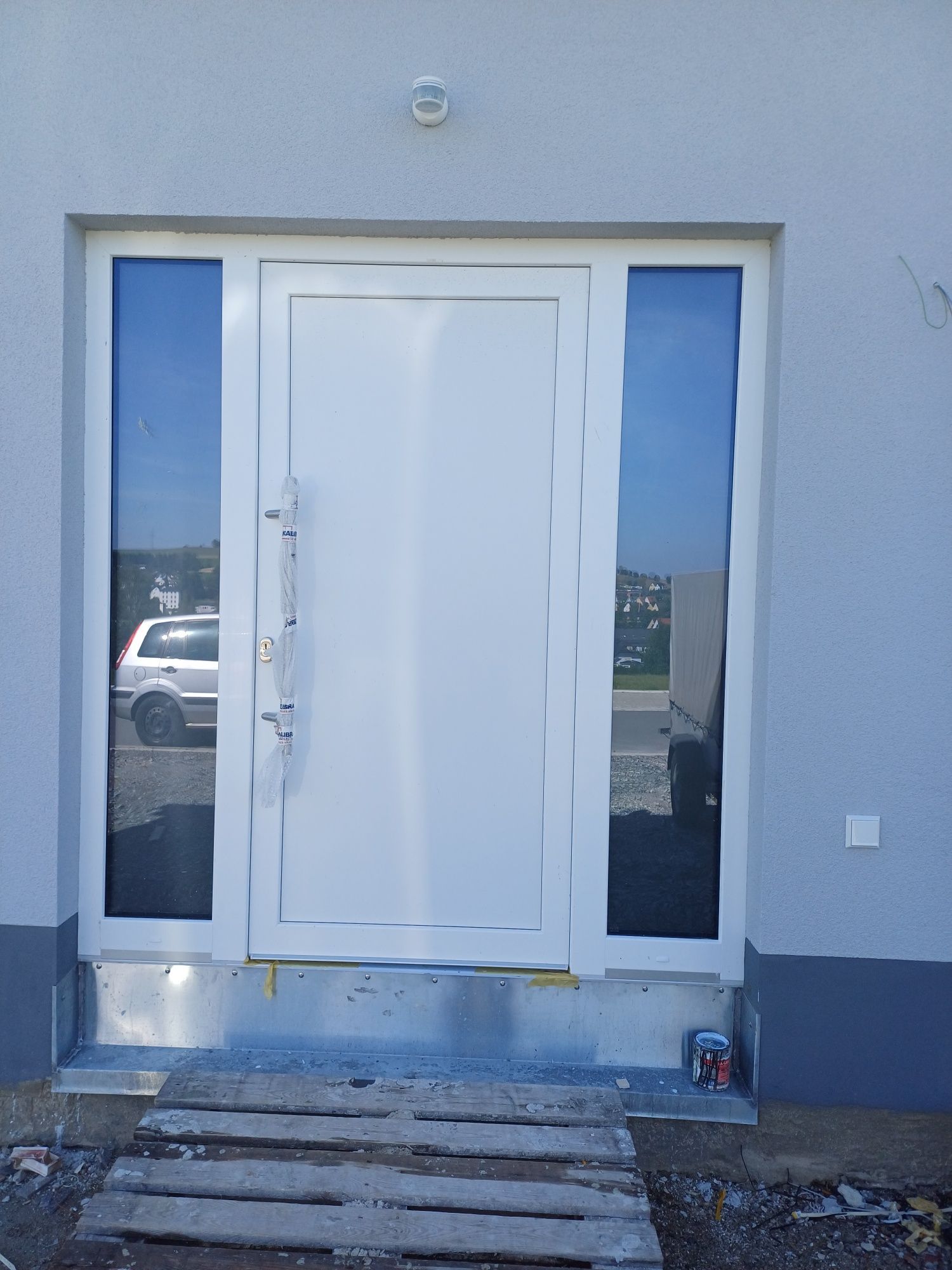 Eine weiße Tür mit einem davor geparkten Auto