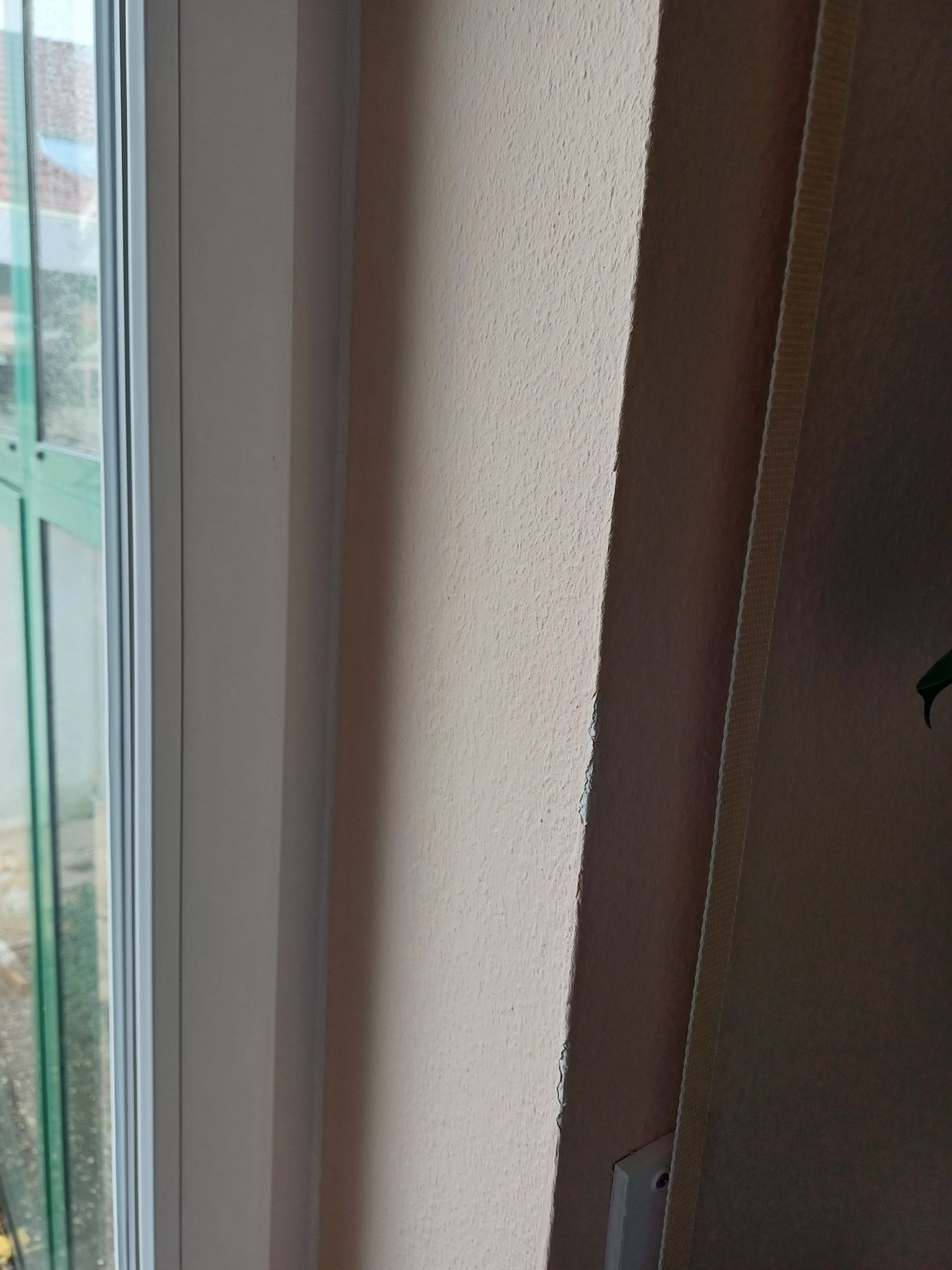 Eine Nahaufnahme eines Fensters in einem Raum mit einer weißen Wand.