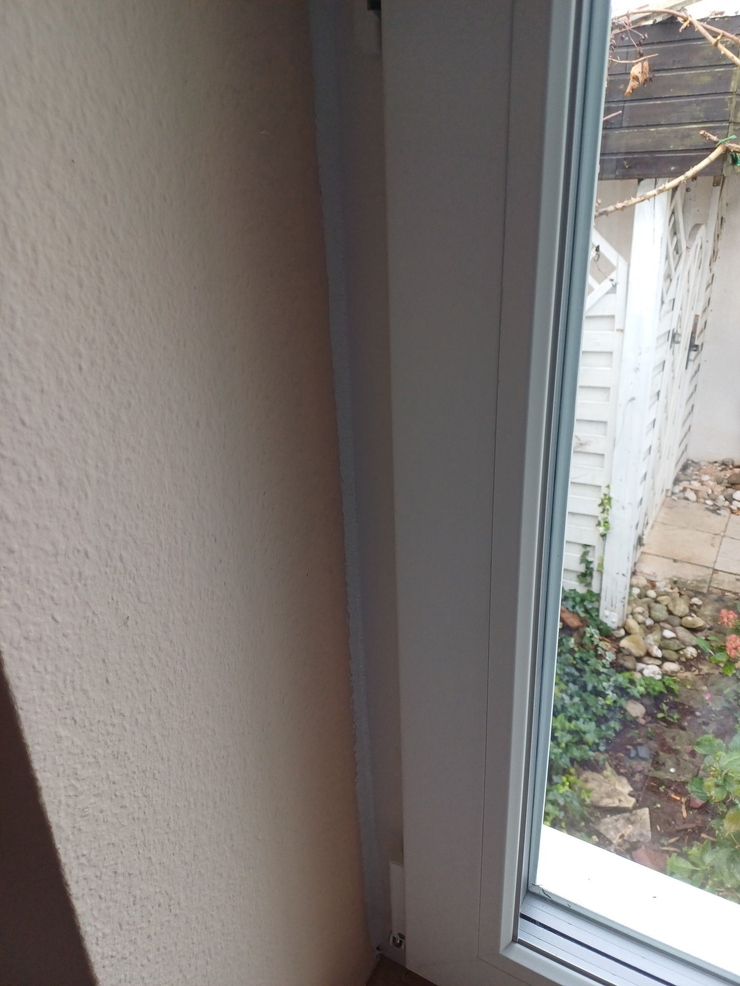 Ein Fenster mit weißem Rahmen geht auf einen Hinterhof hinaus.