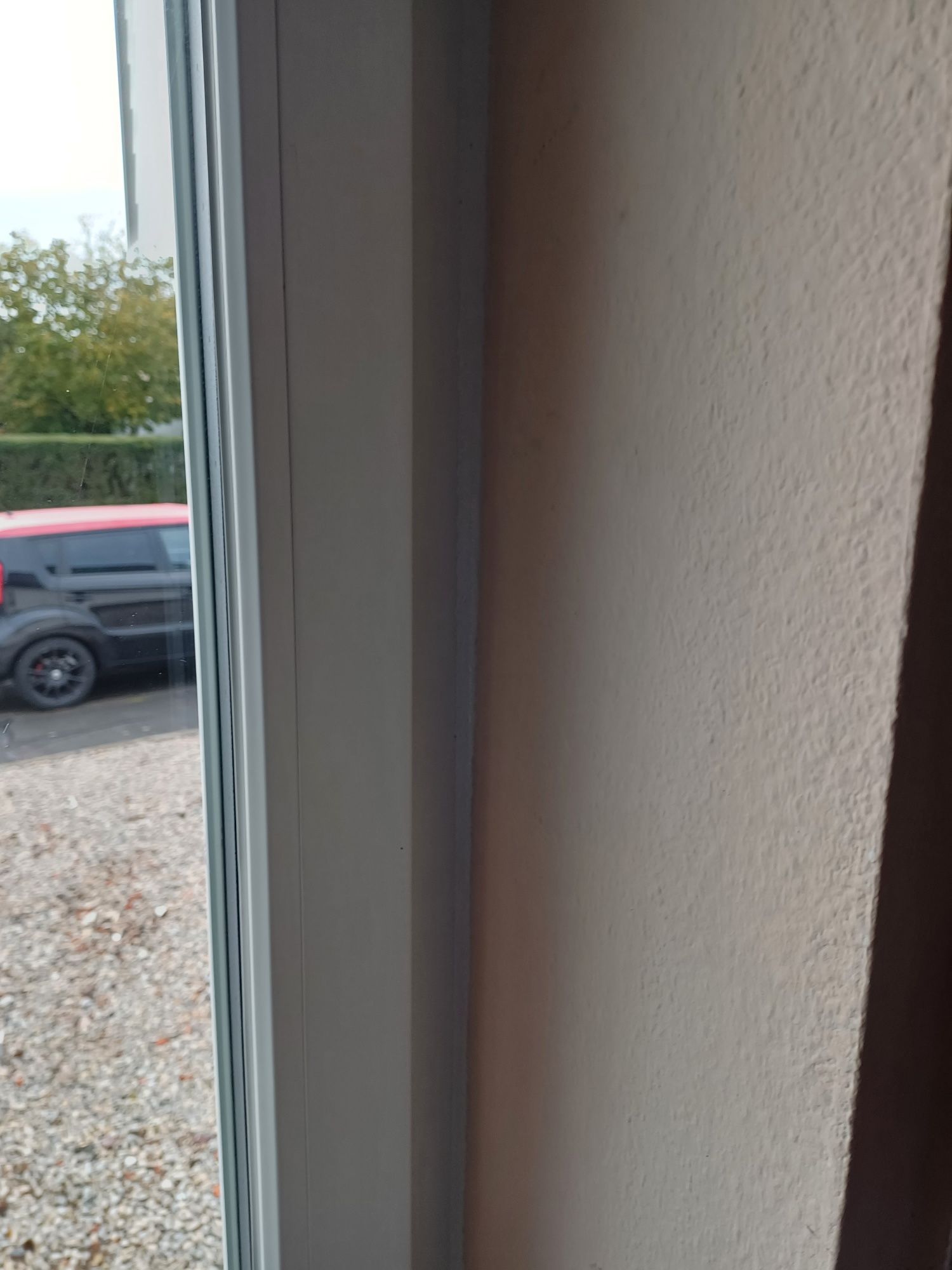 Eine Nahaufnahme eines Fensters mit einem im Hintergrund geparkten Auto.