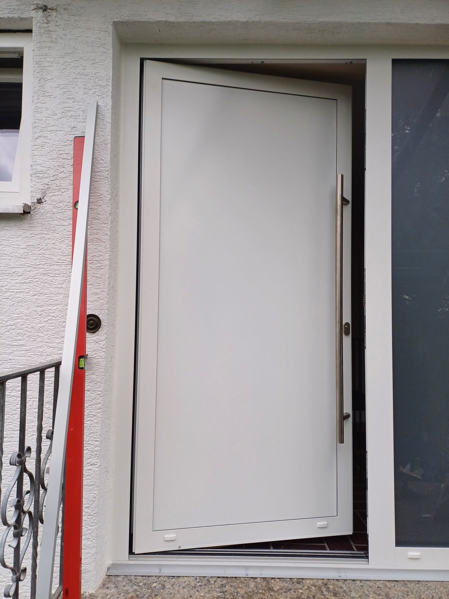 Eine weiße Tür mit einem kaputten Rahmen ist offen