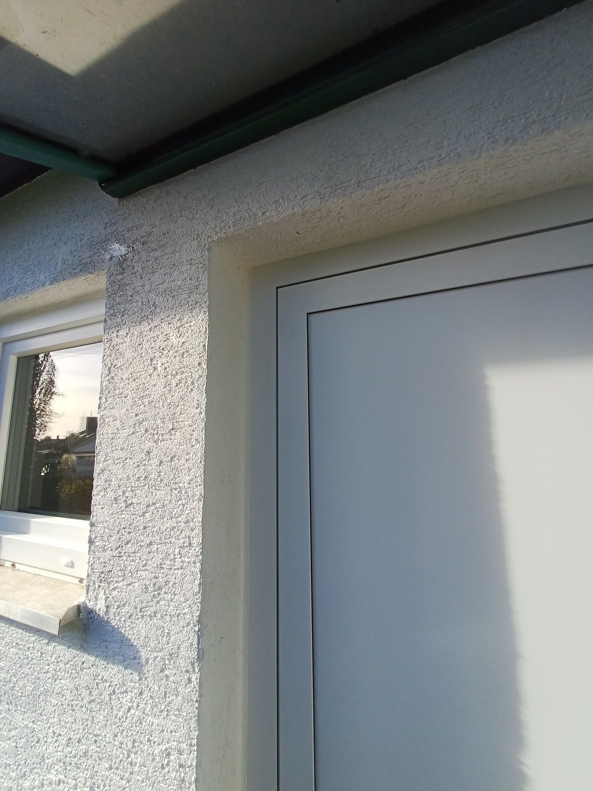 Eine weiße Tür mit einem Fenster an der Seite eines Gebäudes