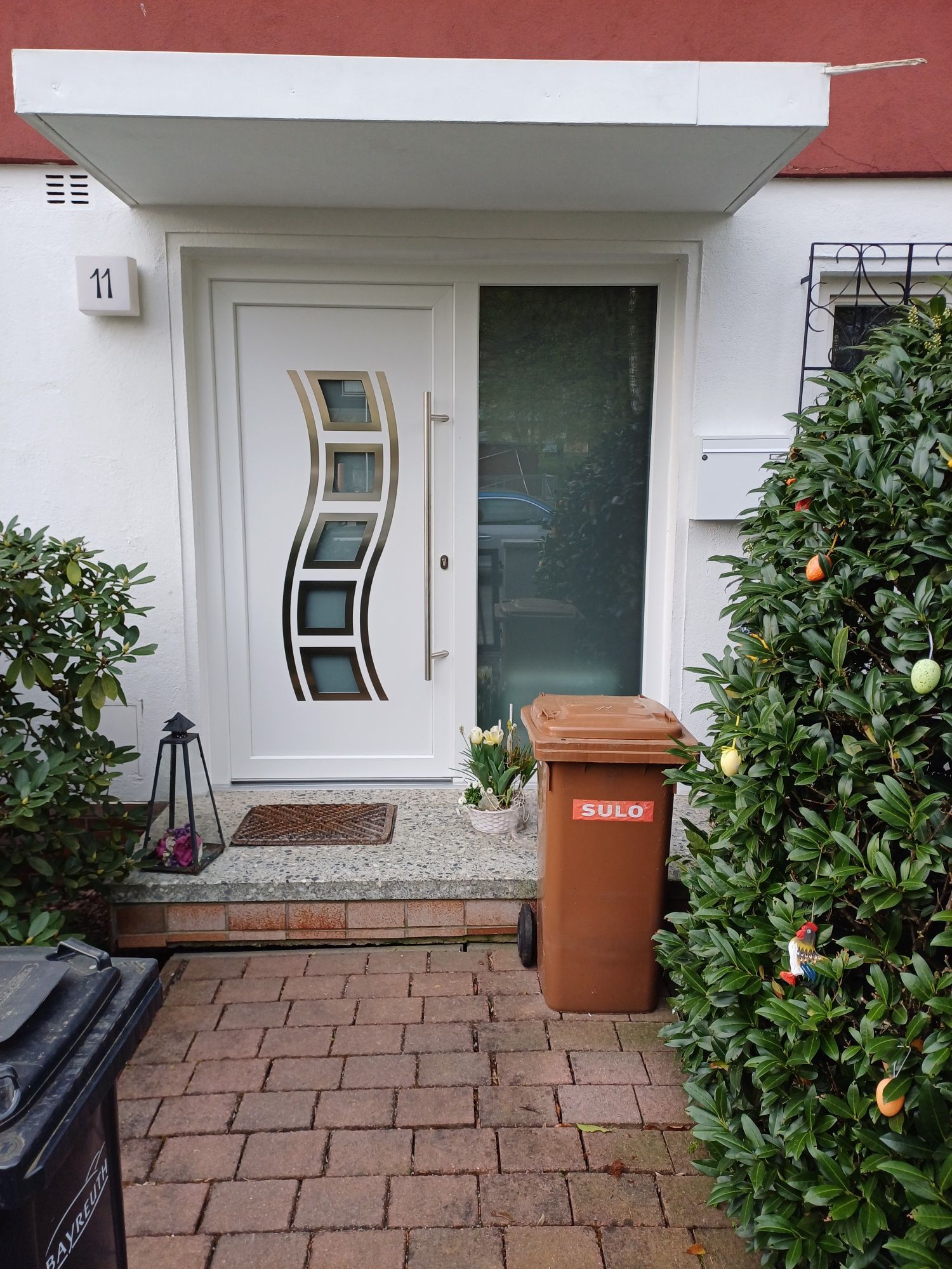 Eine weiße Tür mit einem braunen Mülleimer davor