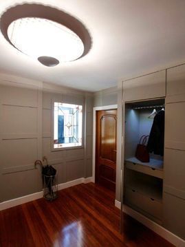 Un pasillo con pisos de madera y una ventana.