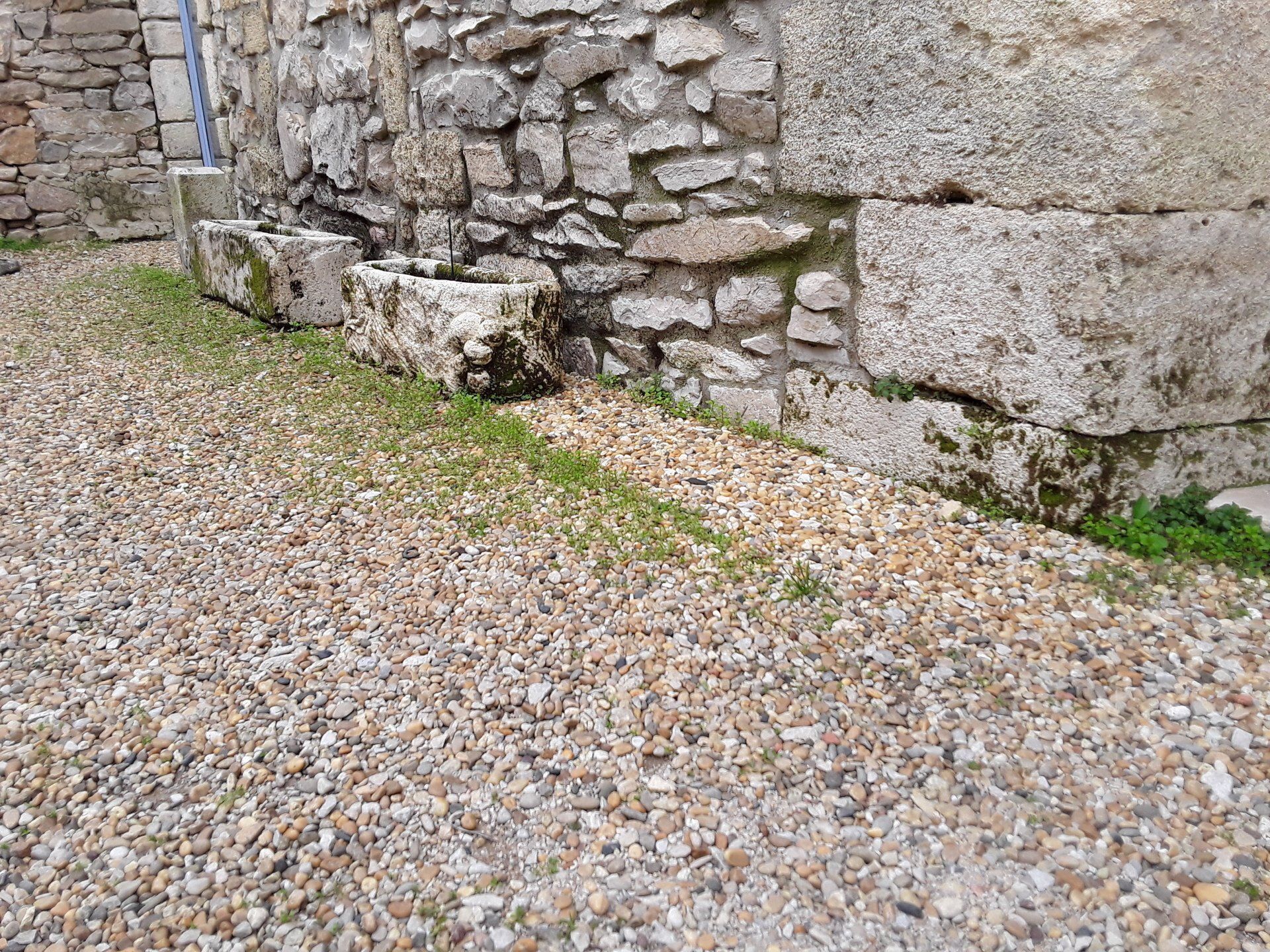 Graviers devant un mur en pierre