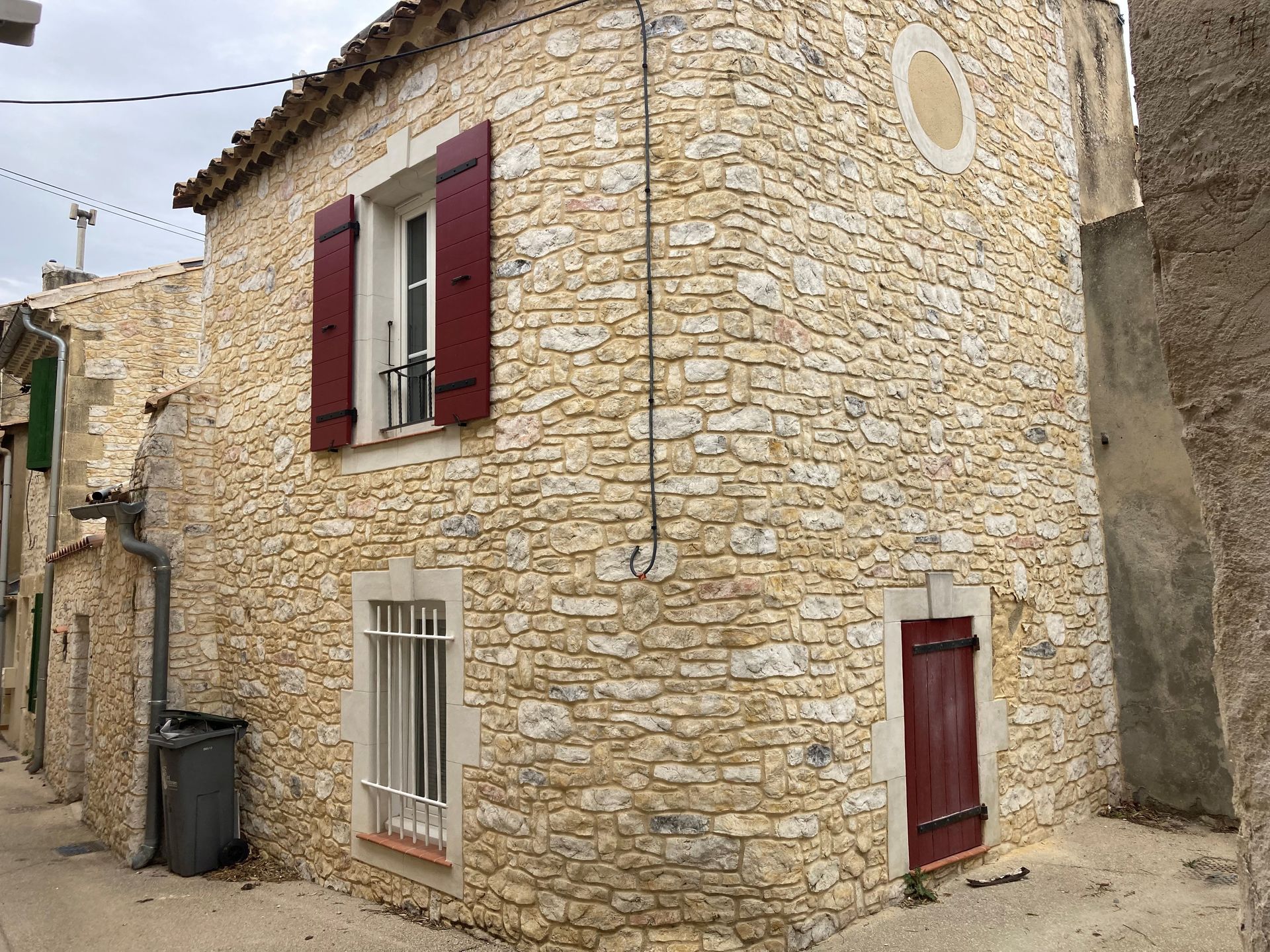 Facade en pierre avec volets rouges