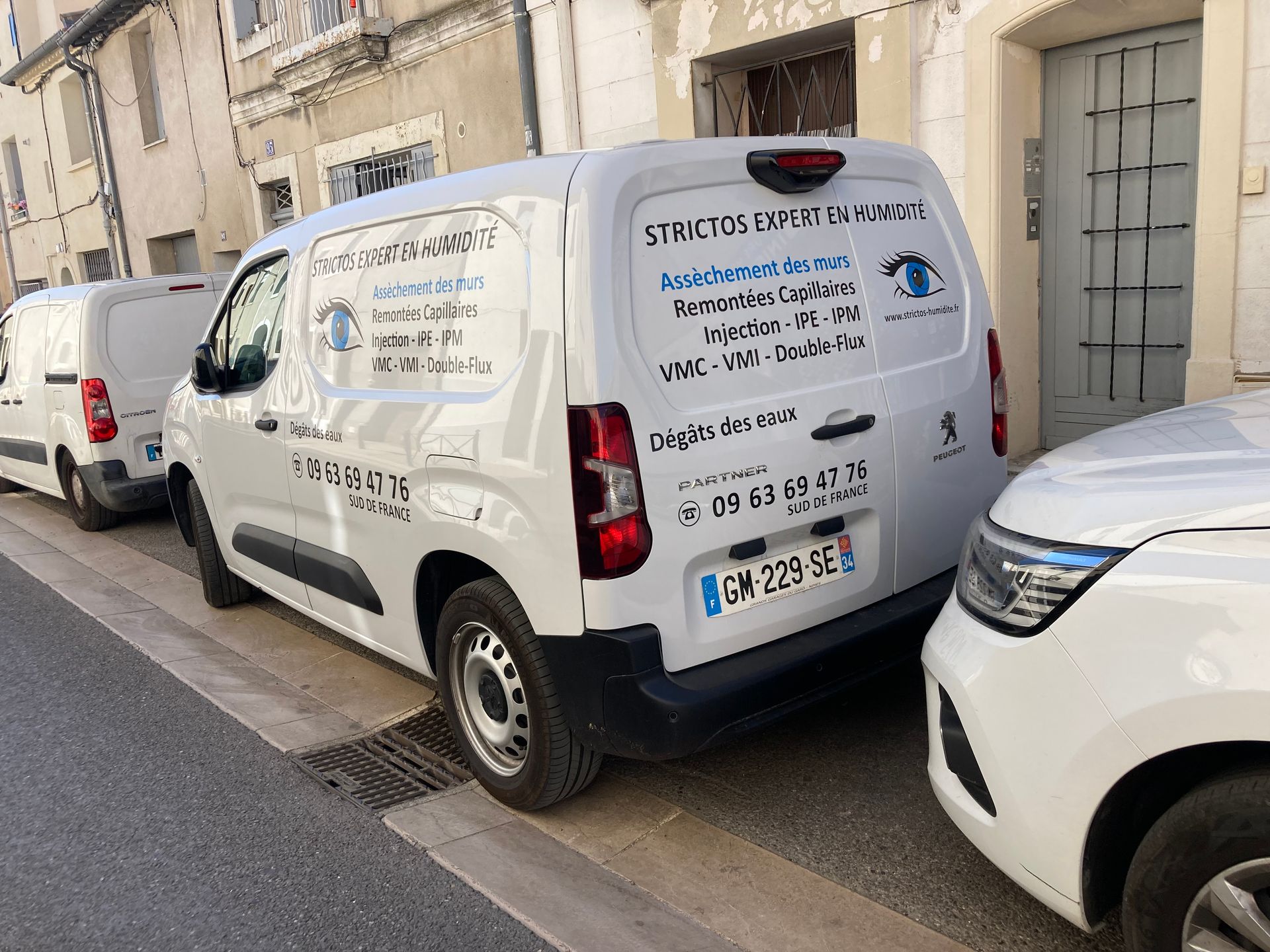 Camionnette blanche STRICTOS entre deux autres voitures blanches