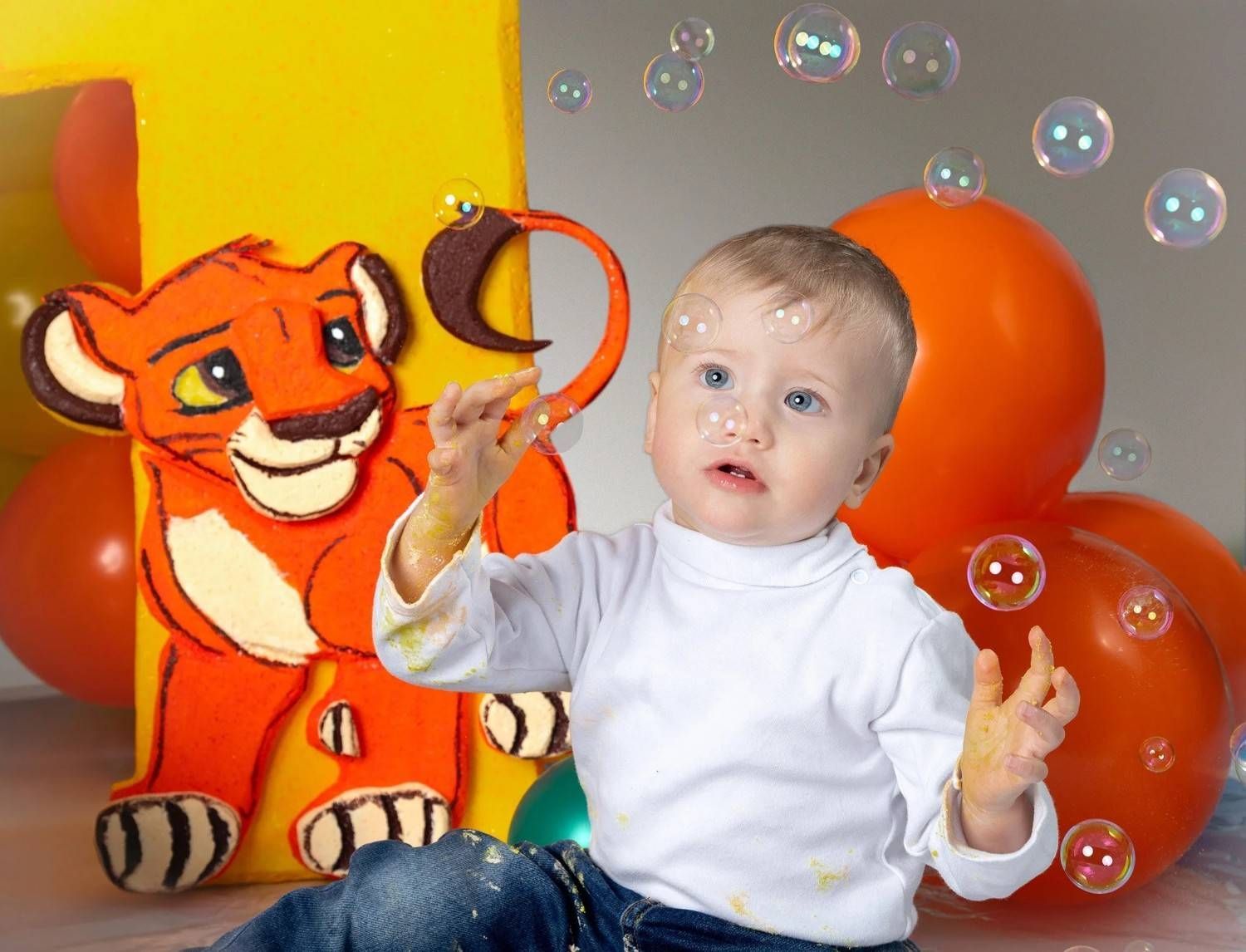 Un bebé sentado entre globos naranjas con burbujas, junto a un peluche de tigre naranja sonriente.