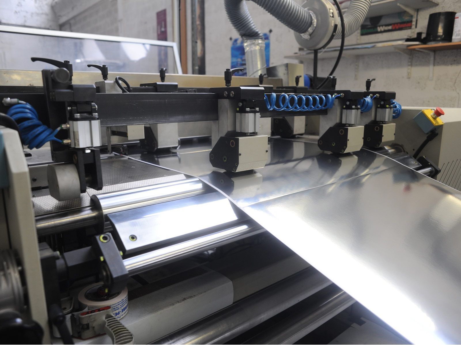 Une tôle est traitée par une machine industrielle de découpe.