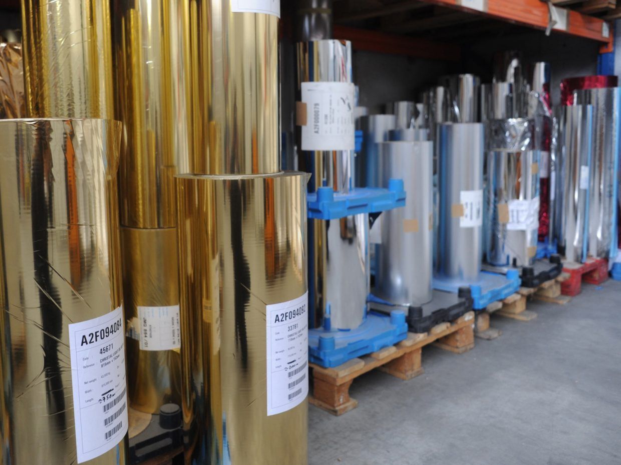 Rouleaux de feuilles d'or et d'argent stockés dans un entrepôt.