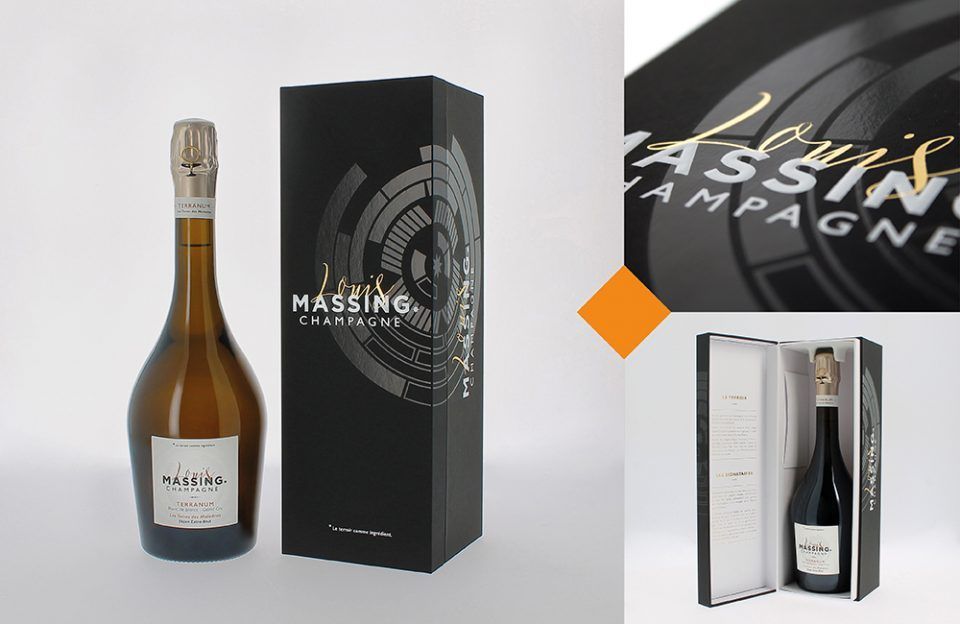 Packaging de boîte de champagne à côté d'une bouteille.