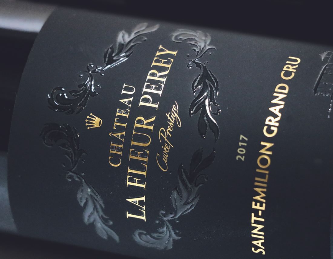 Étiquette de bouteille de vin avec écritures brillantes sur un pelliculage soft-touch.