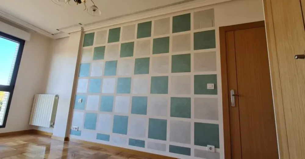 Habitación con pared a cuadros en tonos azules y grises. Puerta, ventana y calefactor marrones.