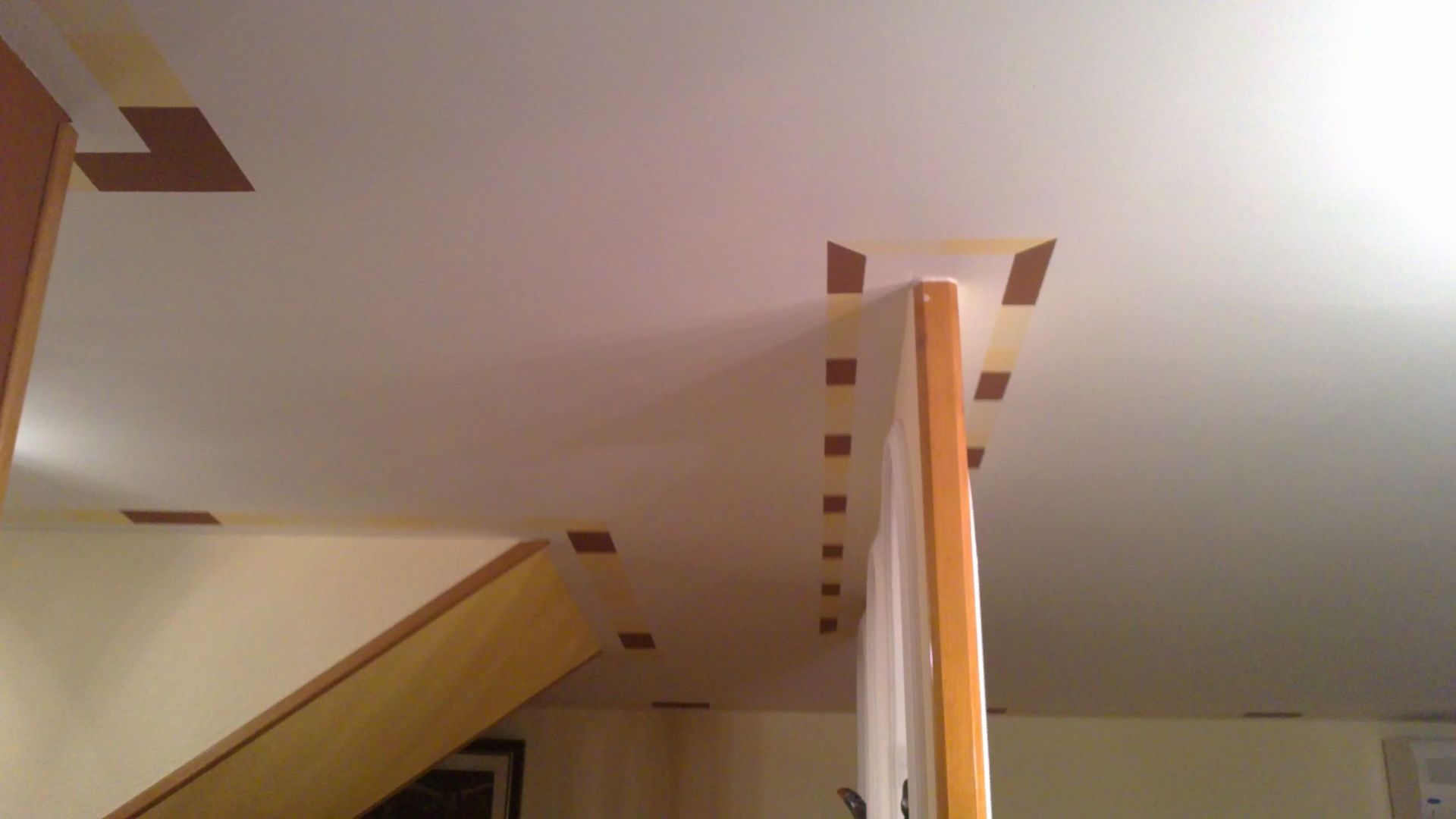 Una habitación con una escalera y un techo que se está pintando.