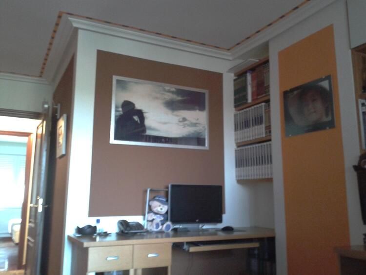 Una habitación con un escritorio y un cuadro en la pared.