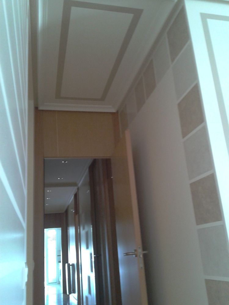 Un pasillo con una puerta y un techo.