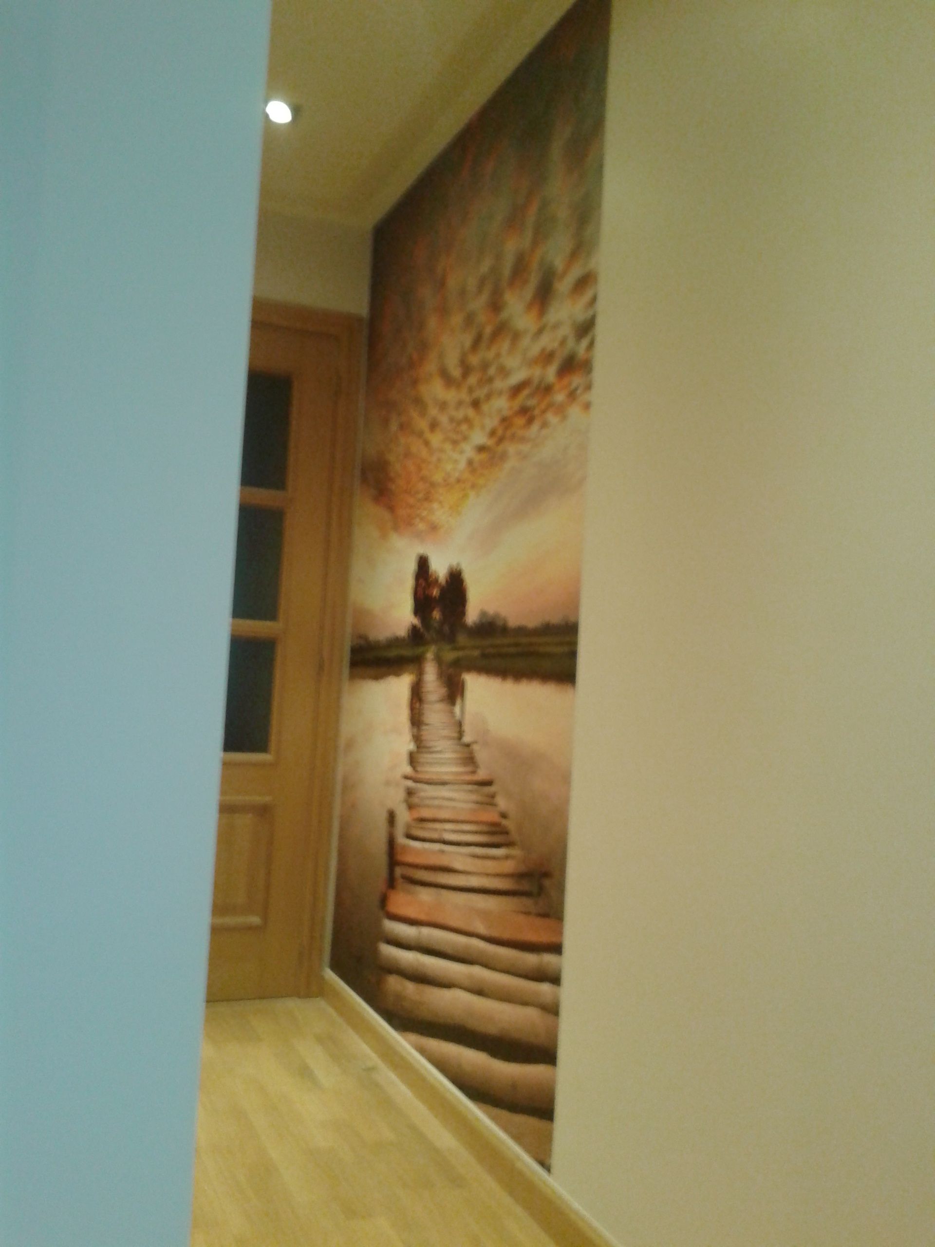 Un pasillo con una pintura de una pareja caminando por un muelle.