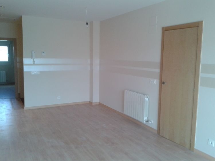 Una habitación vacía con un radiador y una puerta