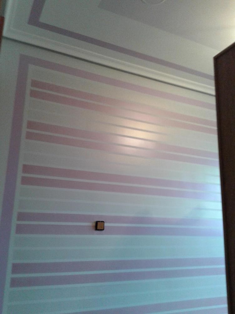 Una pared con rayas rosas y blancas pintadas.