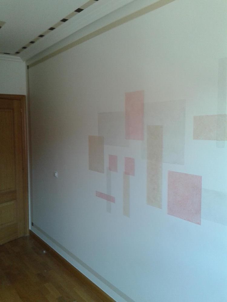 Una pared blanca con cuadrados rosas en una habitación.
