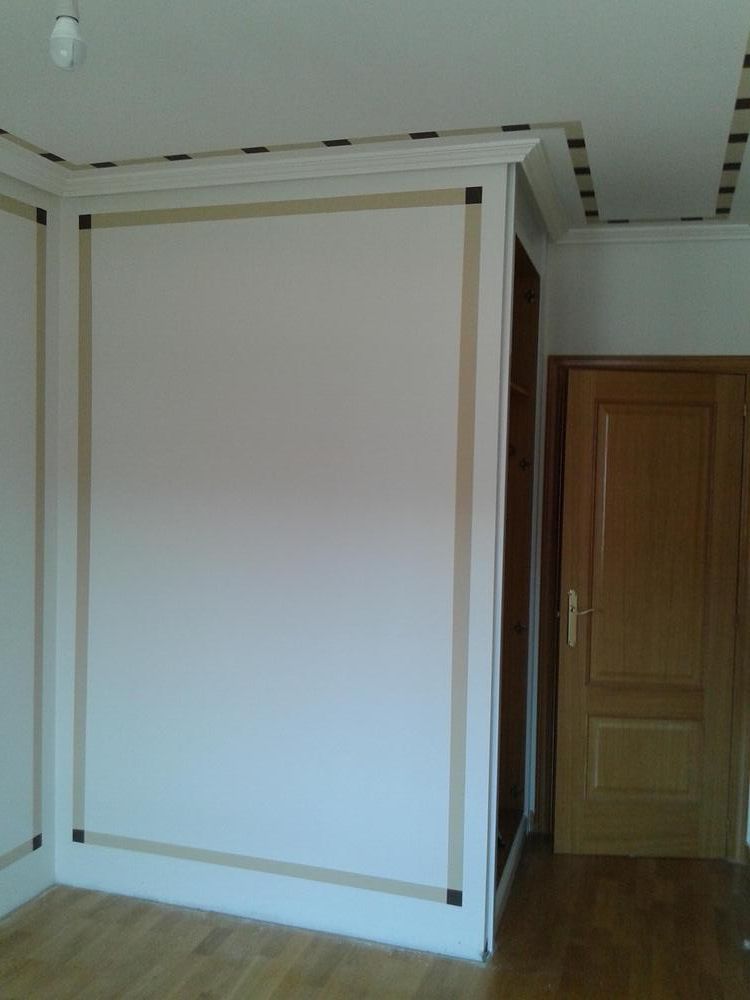Una habitación vacía con una puerta y una pared blanca