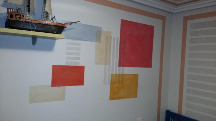 Una habitación con un barco en un estante y un cuadro en la pared.